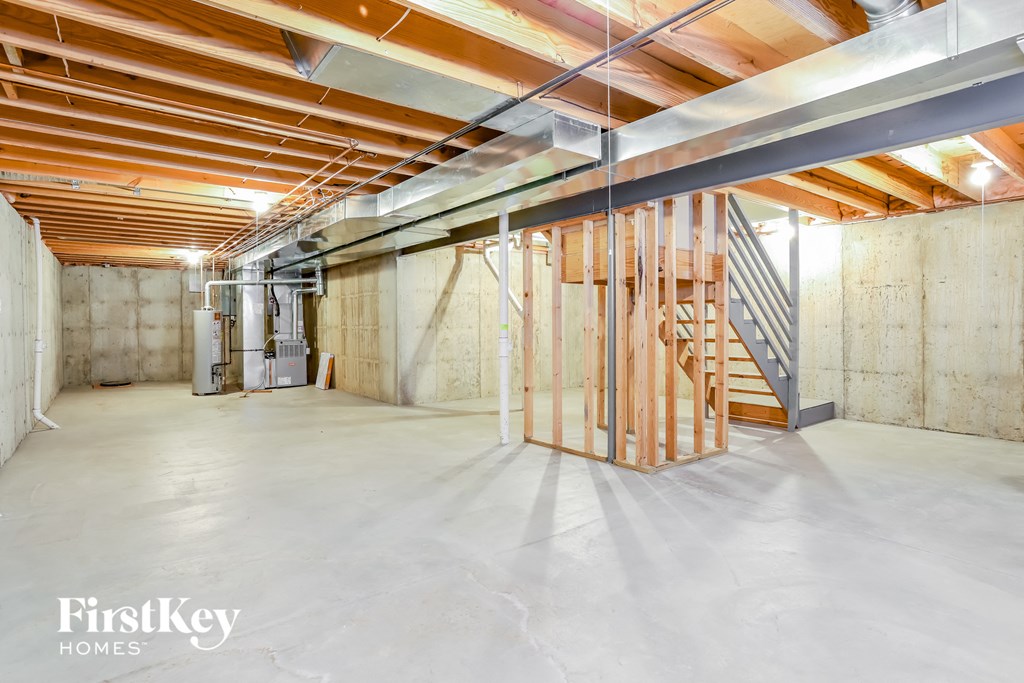 a basement with unfinished wood beams and a staircase