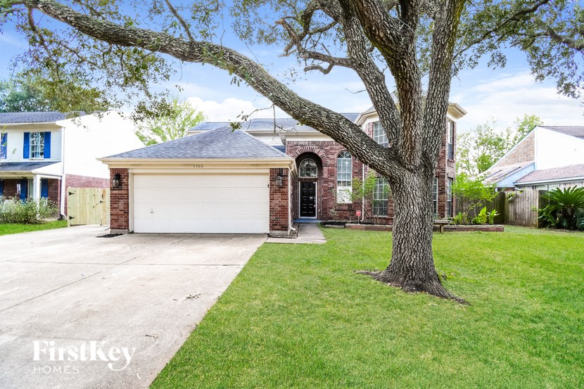 a house with a garage and a tree in the yard