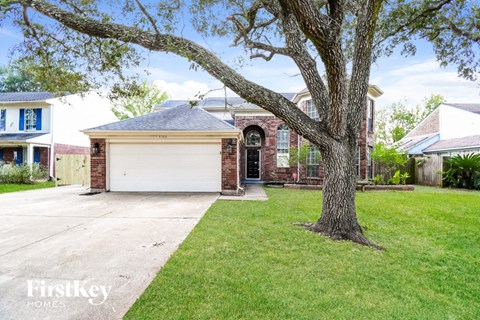 a house with a garage and a tree in the yard