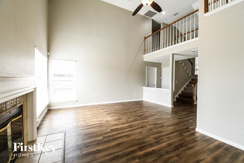 a living room with hardwood floors and a fireplace and a staircase