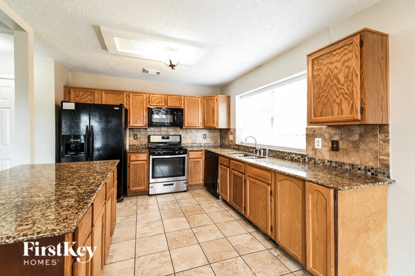 a kitchen with wooden cabinets and granite counter tops