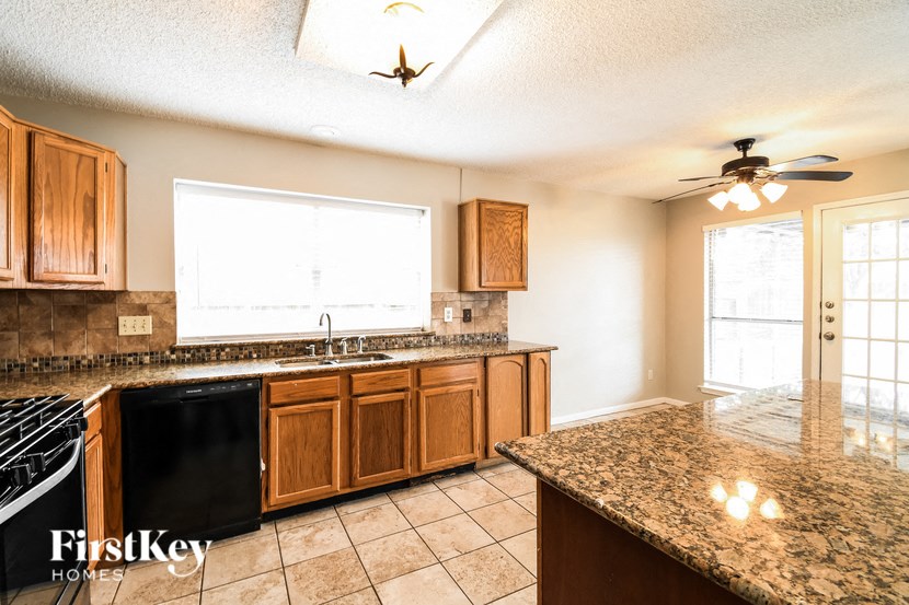 a kitchen with wooden cabinets and a granite counter top