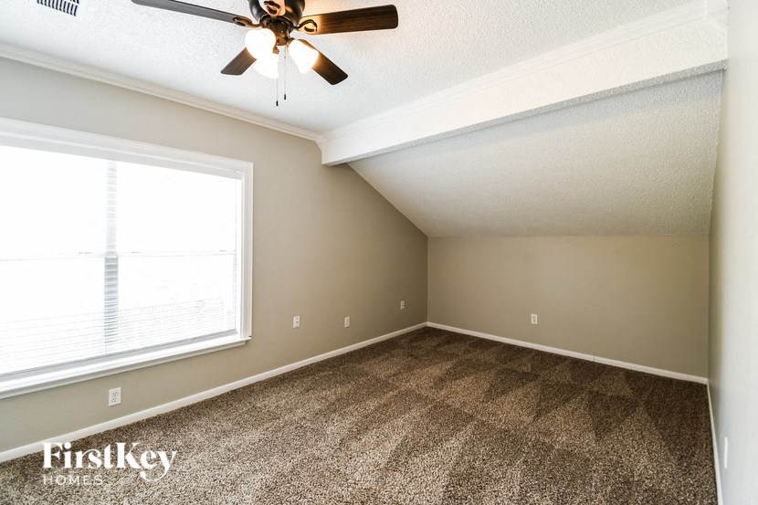 a bedroom with carpet and a ceiling fan