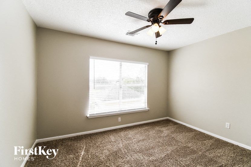a bedroom with a ceiling fan and a window