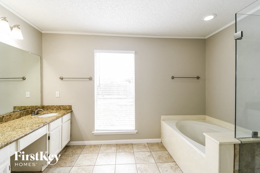 a bathroom with a tub and a sink and a window