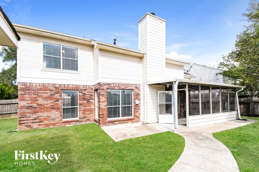 the exterior of a white house with a patio and grass