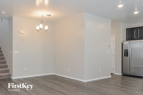 the living room and kitchen of an apartment with a stainless steel refrigerator