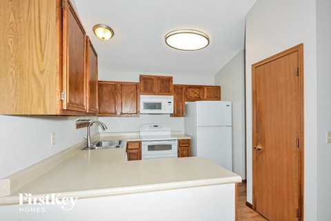 a kitchen with white appliances and wooden cabinets