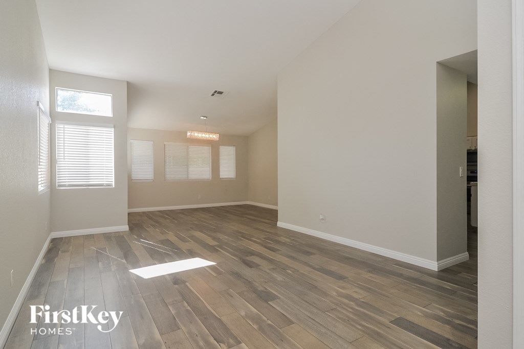a spacious living room with wood floors and white walls