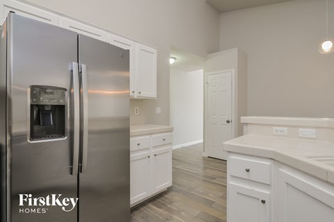 a kitchen with white cabinets and a stainless steel refrigerator