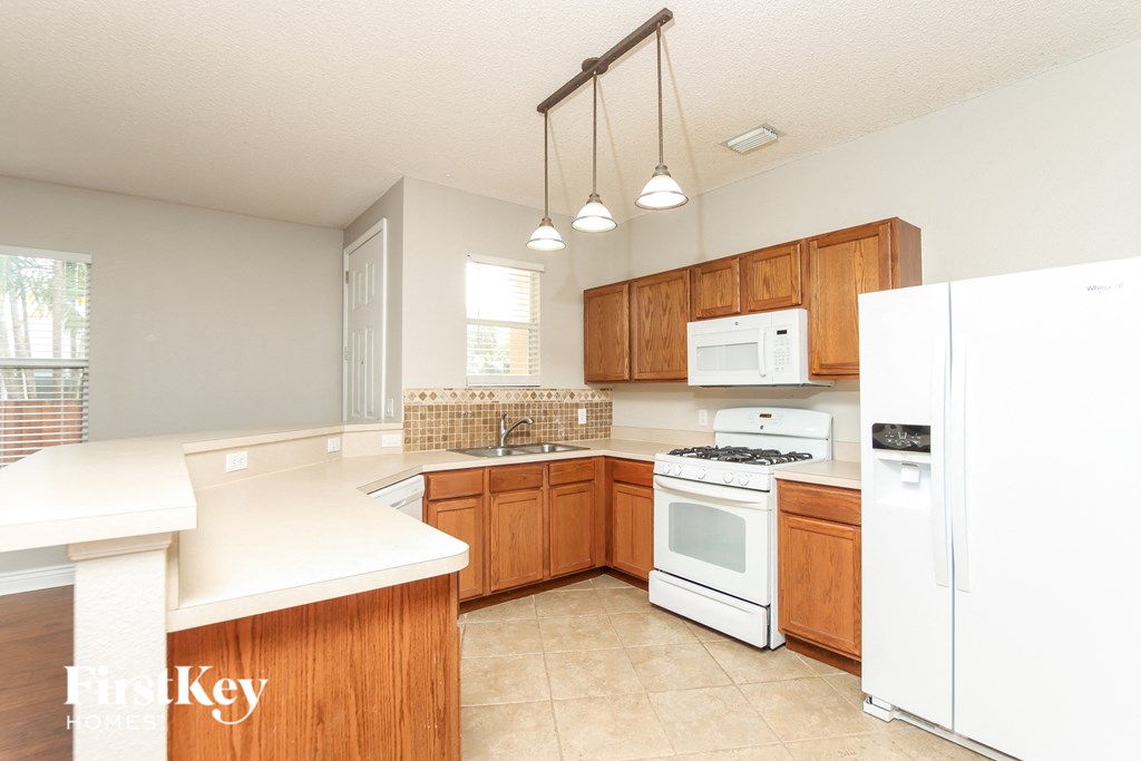 a kitchen with white appliances and wooden cabinets