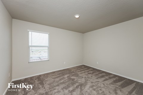 a bedroom with carpet and a window