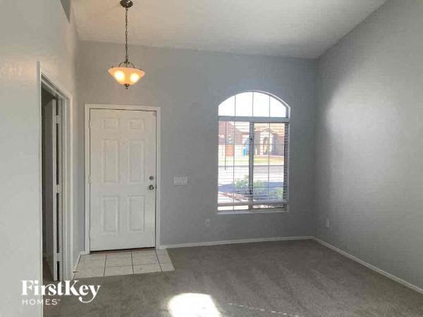 A room with a white door and a window with a view of a parking lot.