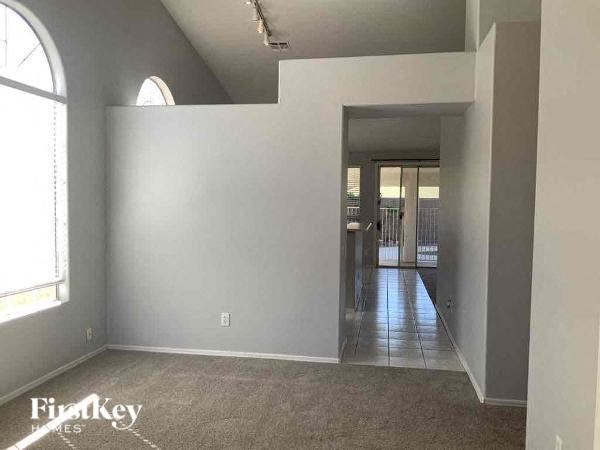 A room with a large window and a door leading to another room.