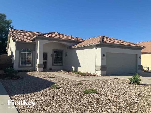 A house with a gravel driveway in front of it.