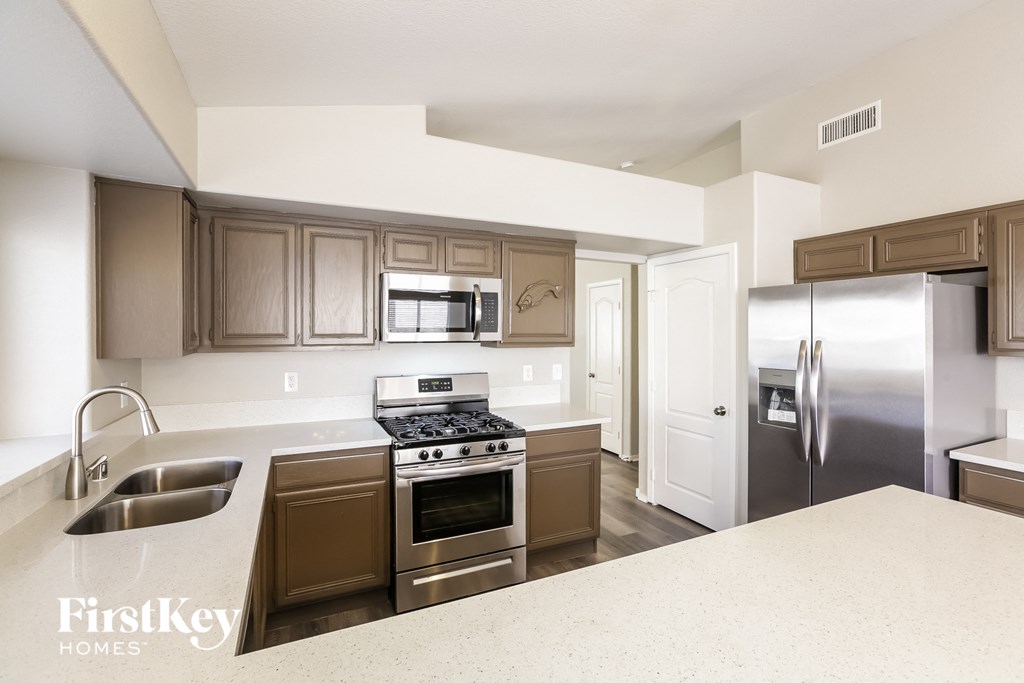 a kitchen with stainless steel appliances and white counter tops