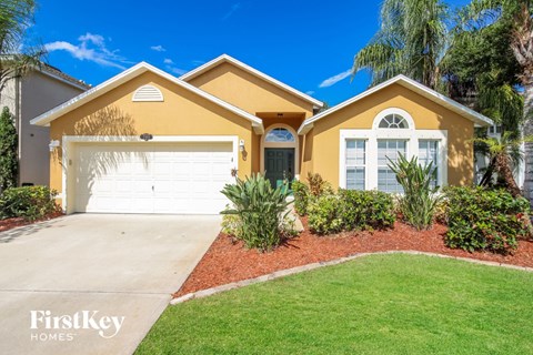 a yellow house with a driveway and a garage door