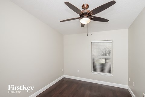 a bedroom with a ceiling fan and a window
