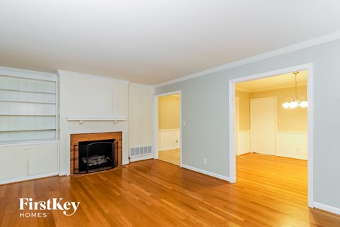 a living room with a fireplace and wooden floors