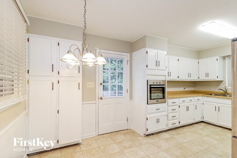 a large white kitchen with white cabinets and a window