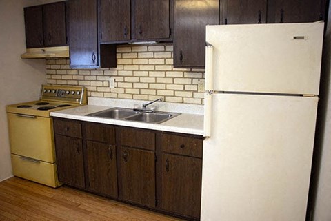a kitchen with a white refrigerator and a sink