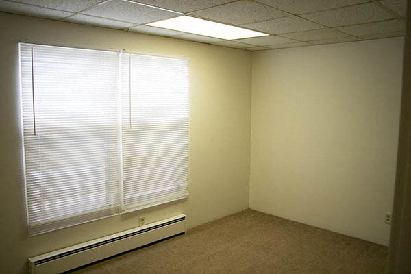 an empty room with a large window and a window sill