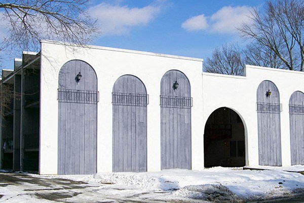 a white building with five doors and three arched doors