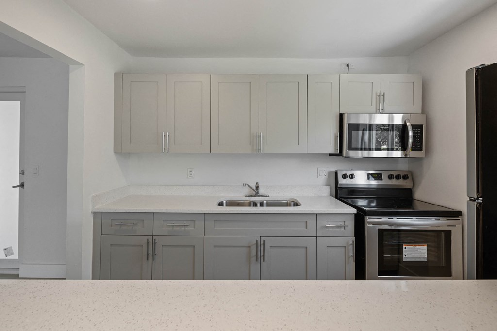 a kitchen with white cabinets and stainless steel appliances