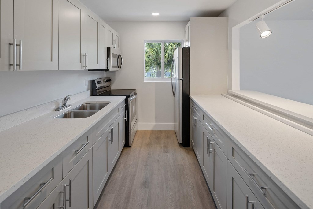 a kitchen with white cabinets and a sink and a refrigerator