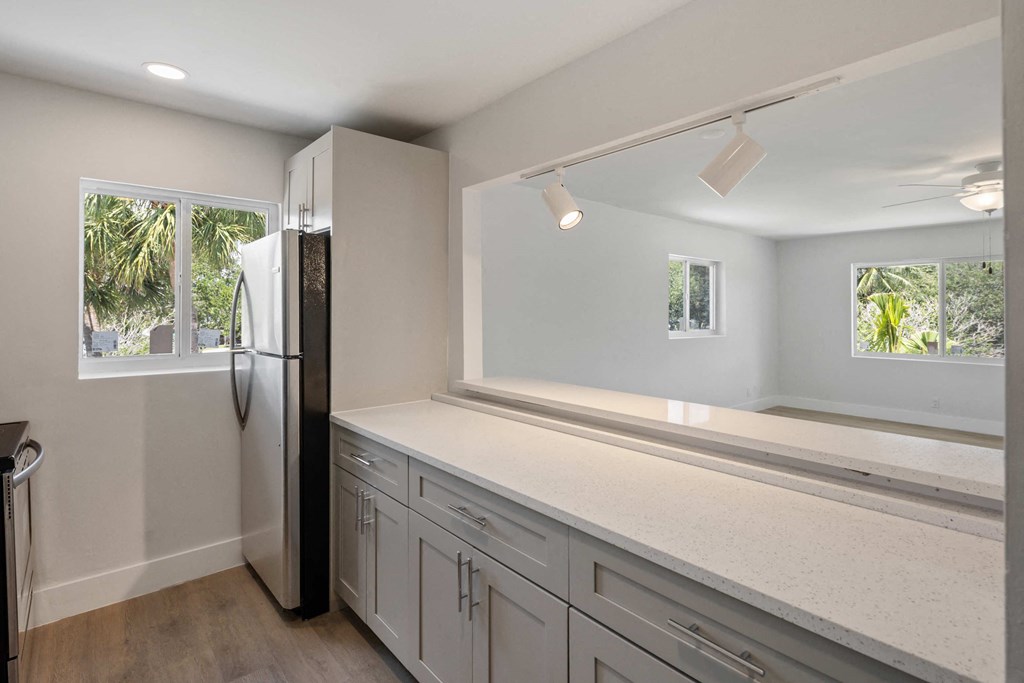 a white kitchen with white cabinets and a black refrigerator