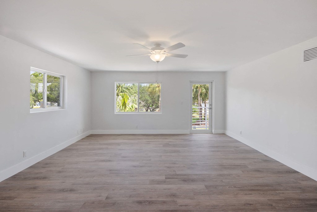 an empty living room with white walls and a ceiling fan
