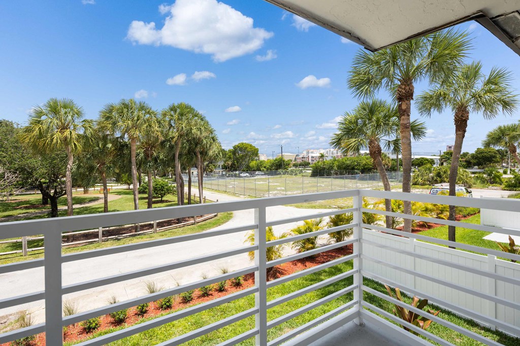 the view from the balcony of a condo with palm trees