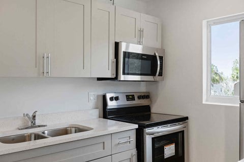a kitchen with a stove microwave and sink