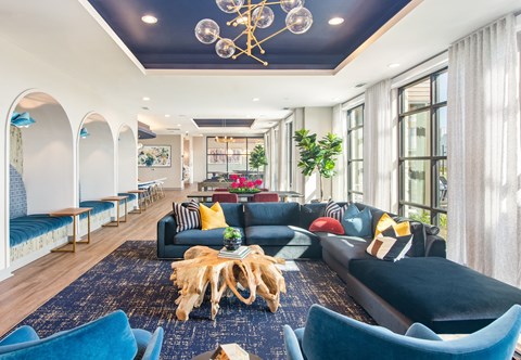a living room with blue couches and chairs and a chandelier