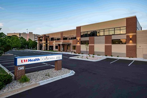 A parking lot in front of a building with a sign that says LW Health.