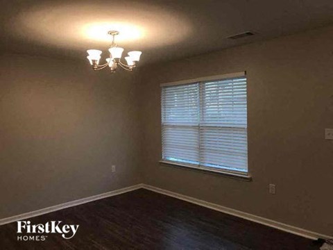 a empty room with a window and a chandelier