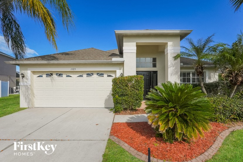 A house with a garage and a driveway in front of it.