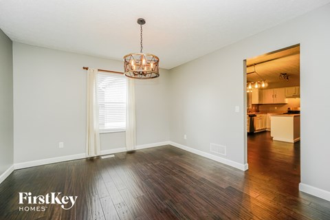 an empty living room with hardwood flooring and a large window