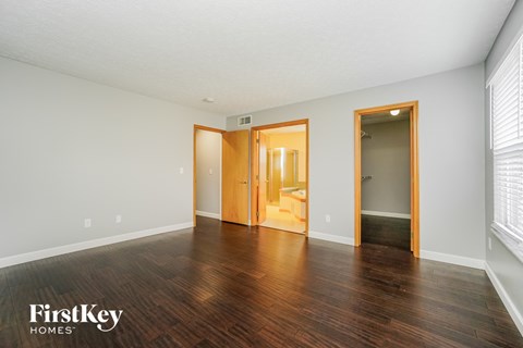 an empty living room with wood flooring and white walls