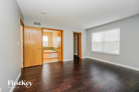 an empty living room with wood floors and a large window