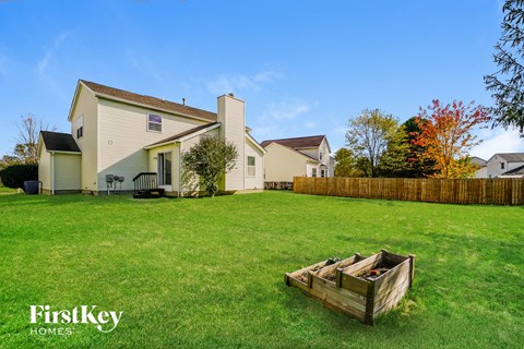 a backyard with a wooden crate in the grass