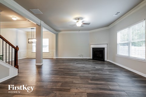 an empty living room with a fireplace and wooden floors
