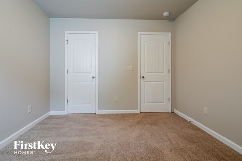 a bedroom with two doors and a carpeted floor