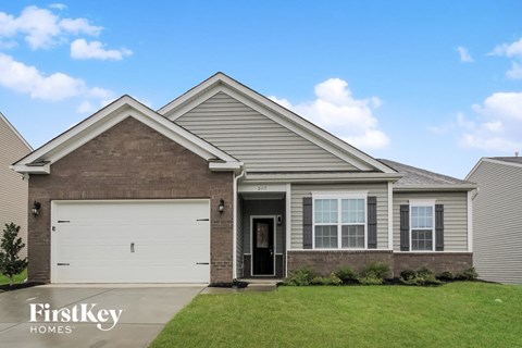 a beige and brown house with a white garage door