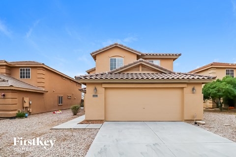 a beige house with a garage and a driveway