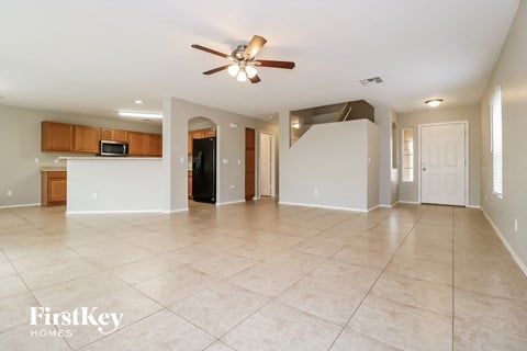 an empty kitchen and living room with a ceiling fan