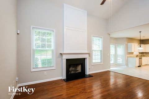 A room with a fireplace and a window with blinds.