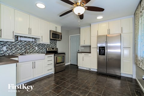 A kitchen with a tile floor and a stainless steel refrigerator.