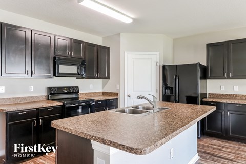 a kitchen with black appliances and a granite counter top