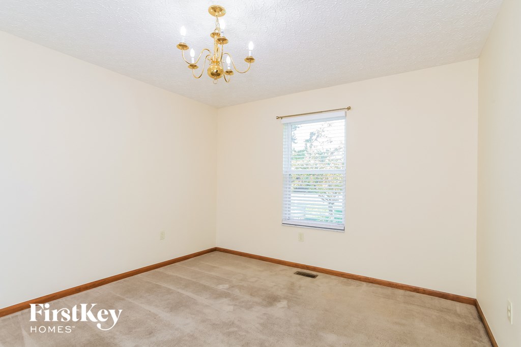 a empty room with a window and a chandelier